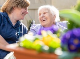 A carer with a resident in the garden at Monson Care Home Lincoln